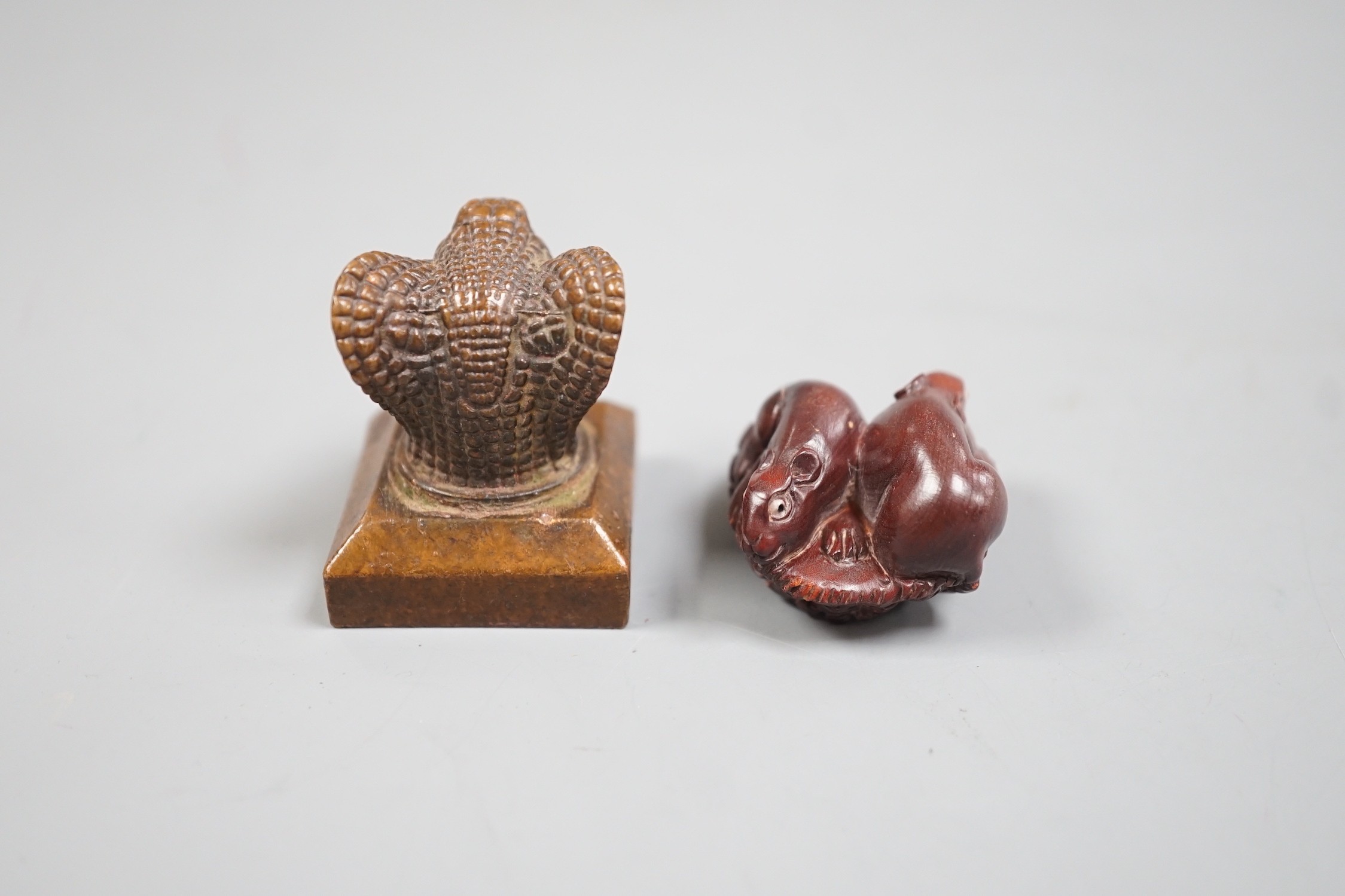 A Chinese bronze 'cobra' seal and a Japanese carved wood netsuke with signed mother of pearl tablet to underside. Seal 4cm tall